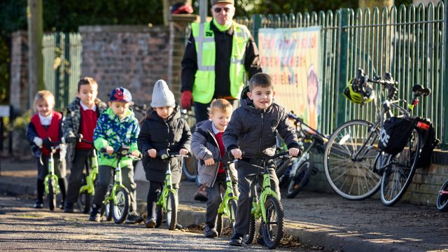Children riding their bikes outside a school